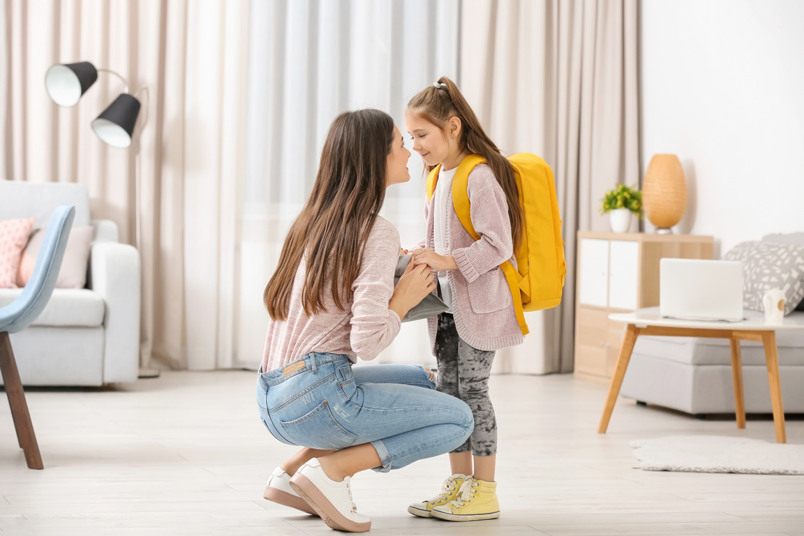 Young Mother Helping Her Daughter Get Ready for School